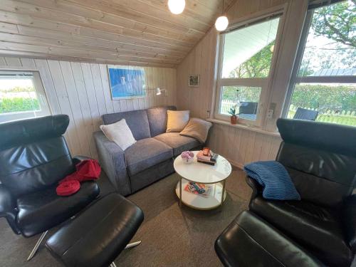 a living room with a couch and chairs and a table at Cozy Holiday Cabin Near Grindsted in Grindsted
