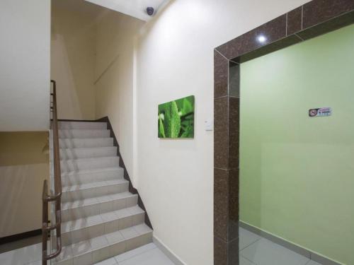 a staircase in a building with a painting on the wall at Hotel Zamburger Sri Petaling in Kuala Lumpur