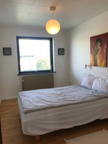 a bedroom with a large white bed with a window at Lovely Holiday Home On Lolland in Errindlev