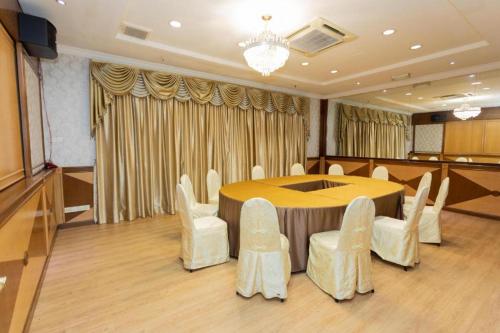 a conference room with a round table and white chairs at Pelican Hotel in Batu Pahat