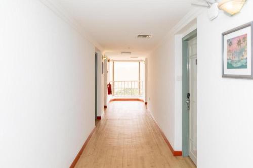 a hallway with white walls and a ceiling fan at Pelican Hotel in Batu Pahat