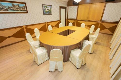 a conference room with a table and white chairs at Pelican Hotel in Batu Pahat