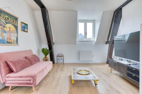- un salon avec un canapé rose et une table basse dans l'établissement Jeanne à dit charmant duplex Vieux Marché à Rouen, à Rouen