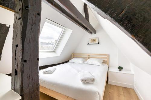 une chambre avec un lit dans un grenier dans l'établissement Jeanne à dit charmant duplex Vieux Marché à Rouen, à Rouen