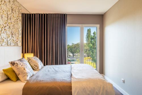 a bedroom with a large bed with a large window at Manny Quinta Vitória, by Pausa Holiday Rentals in Funchal