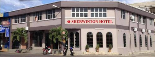 a building with two motorcycles parked in front of it at Sherrinton Hotel in Mentekab