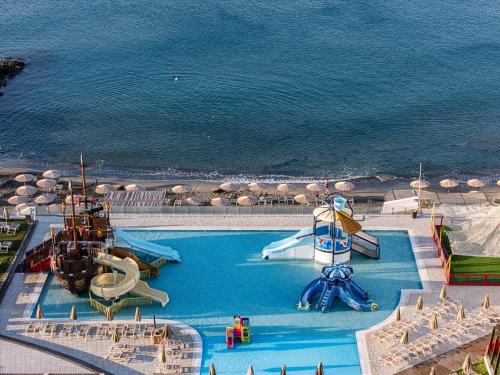 an outdoor swimming pool with a water park and the ocean at Petra Mare in Ierápetra