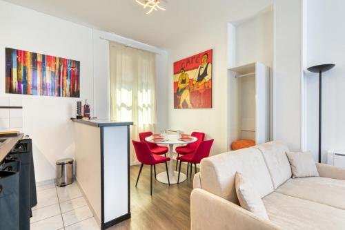 un salon avec un canapé blanc et des chaises rouges dans l'établissement Jean Studio Aitre Saint-Maclou, à Rouen