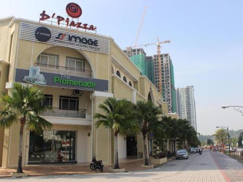 a building on a street with palm trees and buildings at D Nice Hotel in George Town