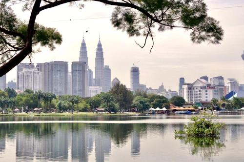 a view of the kuala lumpur city skyline from across a lake at The Hulo Hotel & Gallery in Kuala Lumpur