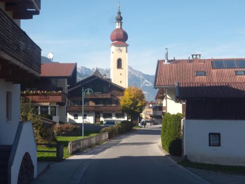a city street with a clock tower in the distance at Appartements Schweiberer in Ried im Zillertal