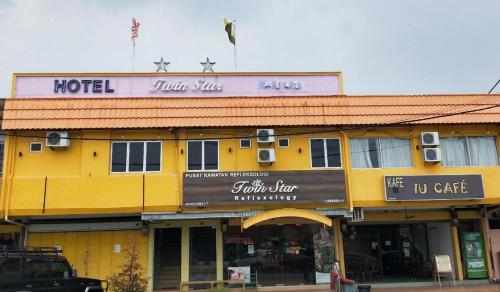 a yellow building with a hotel on top of it at Twin Star Hotel in Tanjung Malim