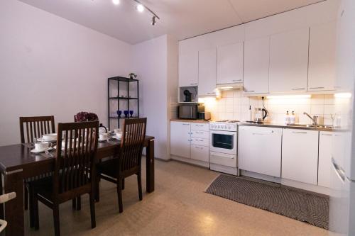 a kitchen with a table and a kitchen with white cabinets at Romantic Sauna Retreat Near Sello and Nature Perfect in Espoo