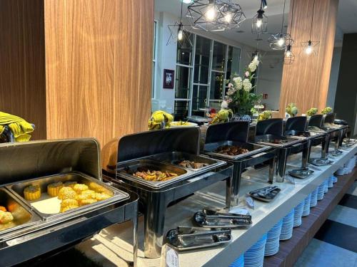 a buffet line with many trays of food at Hotel Scholar's Suites in Tanjung Malim