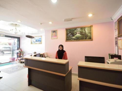 a woman sitting at a counter in a salon at OYO 969 Hotel Pantai View in Labuan