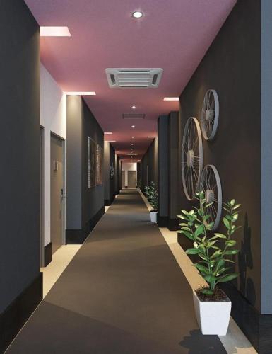 a hallway with a purple ceiling and a hallway with a plant at S Hotel in Johor Bahru