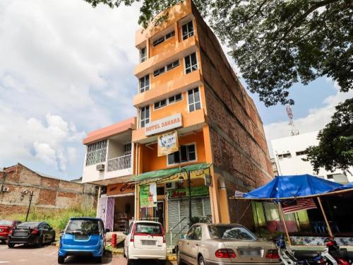 Un edificio con coches aparcados delante. en OYO 89584 Hotel Sahara Kuala Kubu Bharu, en Kuala Kubu Baharu