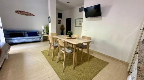 a table and chairs in a living room with a couch at Casa a 65 metros de la Playa in El Palmar