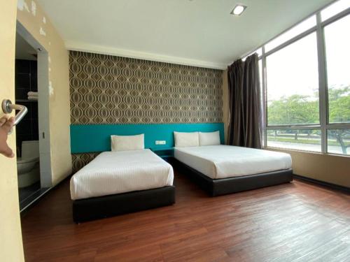 a bedroom with two beds and a large window at OYO 89752 7 DAYS EXPRESS HOTEL in Air Hitam