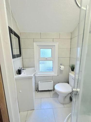 a white bathroom with a toilet and a sink at Entire 3bedroom home can sleep 5 in Gillingham