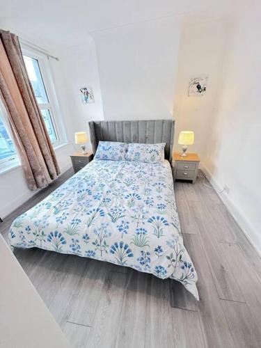 a bedroom with a bed with a blue and white comforter at Entire 3bedroom home can sleep 5 in Gillingham
