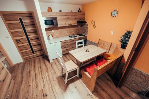 a small kitchen with a table and a dining room at Apartmány Domino in Železná Ruda