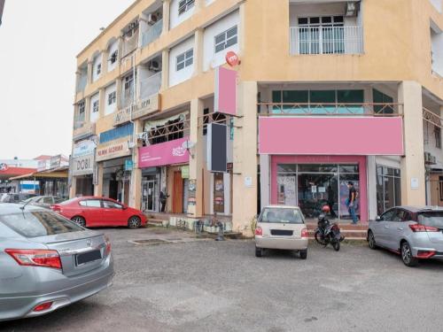 a parking lot with cars parked in front of a building at OYO 90120 MI Hotel Dungun in Dungun