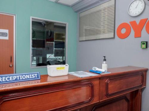 a desk in a room with a clock on the wall at OYO 90120 MI Hotel Dungun in Dungun