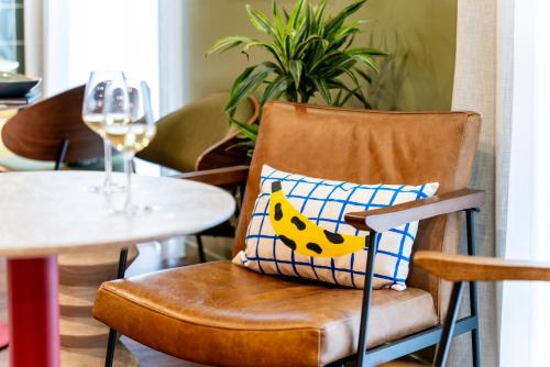 a chair with a pillow on it next to a table at ibis Styles Prévessin Genève Aéroport in Prévessin
