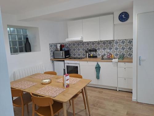 une cuisine avec une table en bois et une table et des chaises dans l'établissement Maison - 4 pièces - 2 personnes, à Limeray