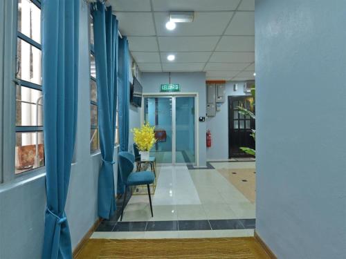 a hallway of a hospital with blue curtains and a chair at OYO 90672 De Paradise Turtle Hotel in Kertih