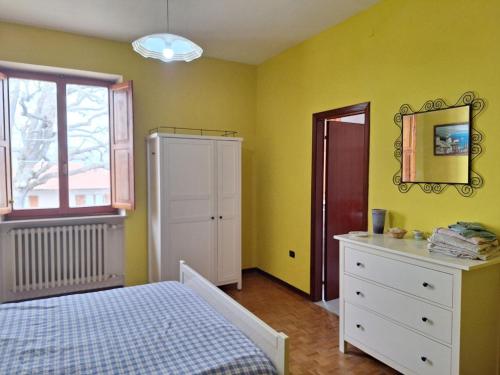 a bedroom with a bed and a dresser and a window at Oak Tree in Montefelcino