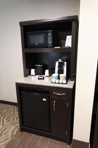a kitchen in a hotel room with a microwave at Hilton Garden Inn Findlay in Findlay
