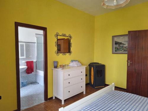a yellow bedroom with a bed and a bathroom at Oak Tree in Montefelcino