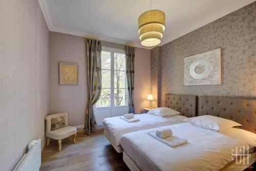 une chambre avec deux lits et une fenêtre dans l'établissement Appartement familial 2 chambres, 2 salles de bains, à Tours