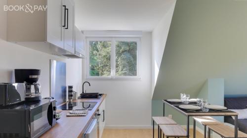 une cuisine avec un comptoir et une fenêtre dans l'établissement Morgane - appt avec jardin partagé, à Bruz