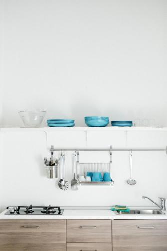 a white kitchen with blue dishes on a shelf at B&B Rosa Dalfonsina in Villalfonsina