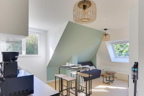 une cuisine avec une table et des chaises dans une pièce dans l'établissement Morgane - appt avec jardin partagé, à Bruz