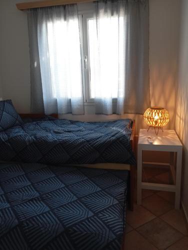 a bedroom with two beds and a lamp and windows at Luxury Beach Villa in Skála