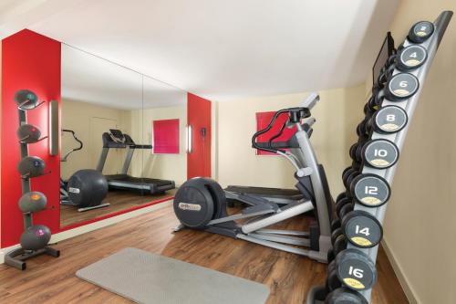 a room with a gym with two tread machines at Ramada London North in Barnet