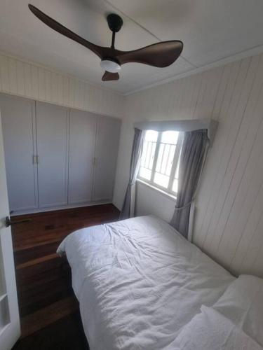 a bedroom with a bed and a ceiling fan at Queensland Charm in Maryborough in Maryborough