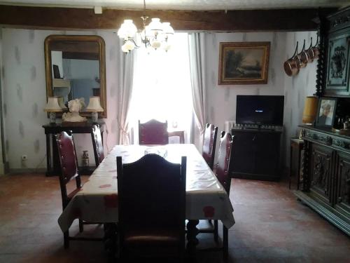une salle à manger avec une table, des chaises et un miroir dans l'établissement Maison conviviale avec jardin à Vauban, 4 chambres, à Vauban
