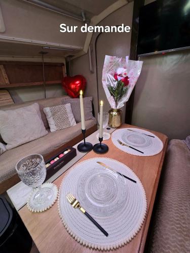 - une table avec deux assiettes et deux bougies dans l'établissement Nuit romantique sur un bateau à Deauville, à Deauville