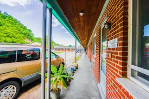 a building with a car parked next to a brick building at Travelers Inn by OYO Beaver, Hwy 19 in Glen Morgan