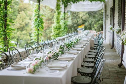 a long table with white tables and chairs with flowers at Castello di Vezio in the Village in Varenna