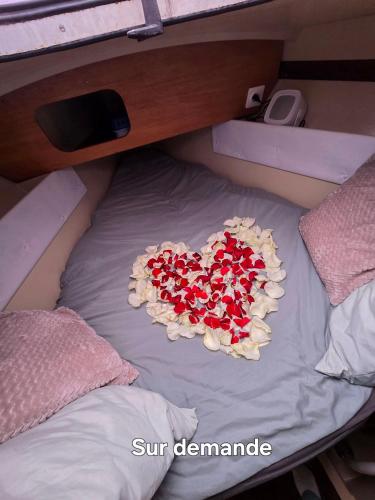 un cœur composé de roses sur un lit dans l'établissement Nuit romantique sur un bateau à Deauville, à Deauville