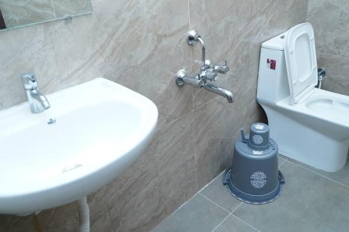 a bathroom with a white sink and a toilet at Veetil 3BHK AC, Kukatpally, Hyderabad in Hyderabad
