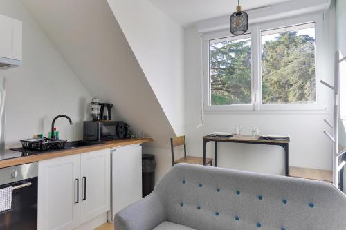 une cuisine avec une chaise, une table et une fenêtre dans l'établissement Viviane - appt avec jardin partagé, à Bruz