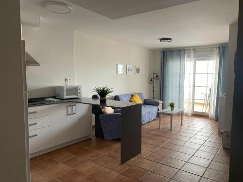 a kitchen and a living room with a couch at Apartahotel Vistamar San José in San José