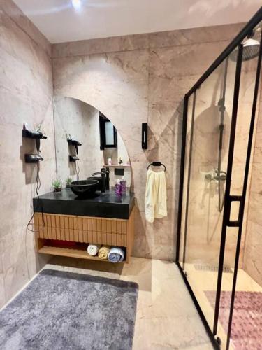a bathroom with a sink and a shower at Attrayant et unique in Mahdia